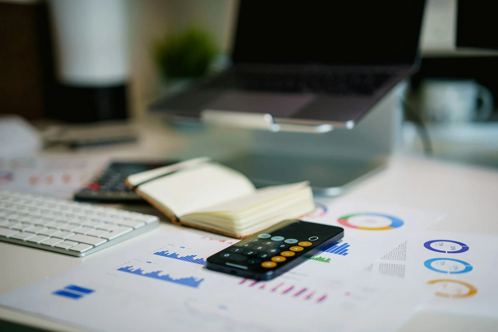 Office desk with financial charts and a smartphone